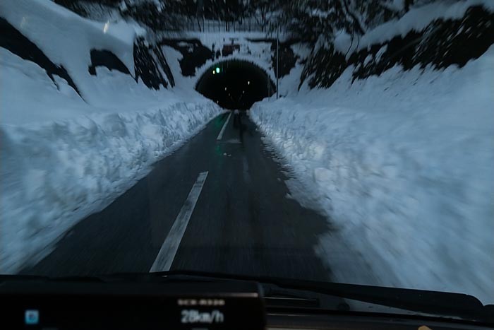 スマホをサンバイザーに貼り付けて撮影。犬上郡多賀町の山奥に向かう道路。このトンネルを抜けると除雪していな道が続いていました。